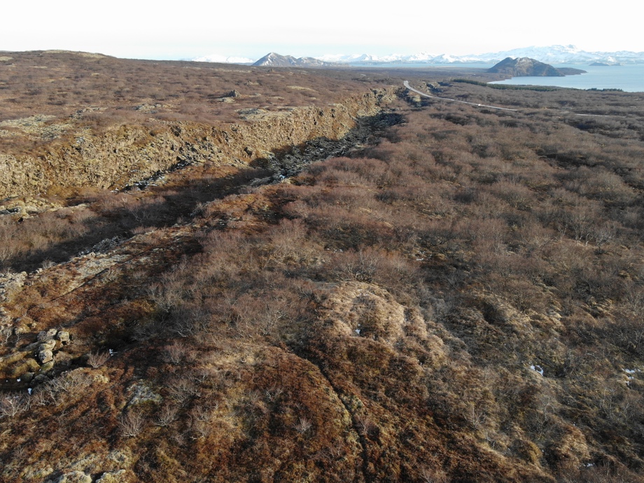 Loftmynd af Hrafnagjá í birkiskóginum. Í fjarska sést í þjóðveg 36 og Arnarfell.