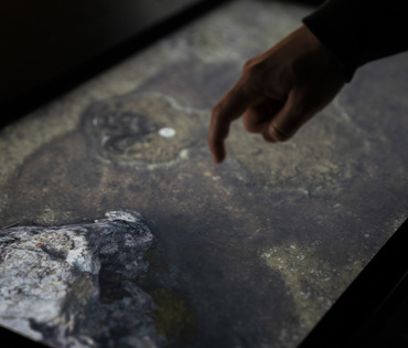 A person looks for artifacts on a screen at the Heart of Iceland exhibit.